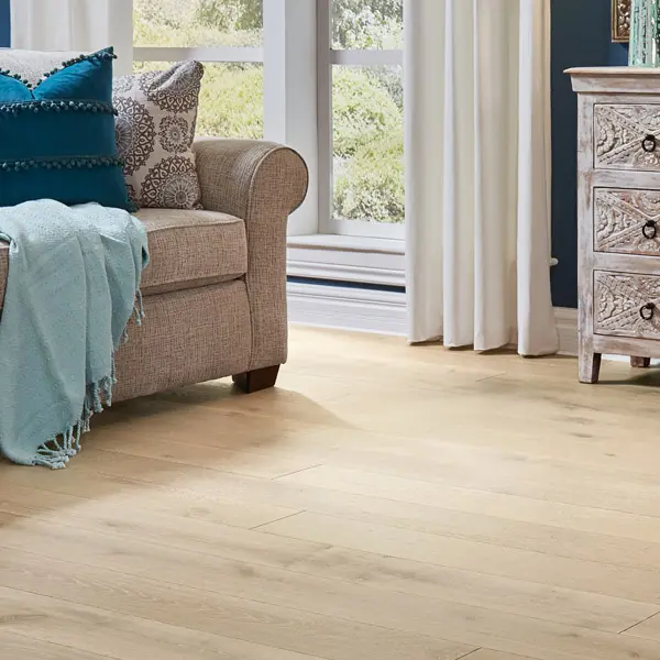 French Oak Plank 1 Living room scene - couch with pillows on light-colored wood-look floor.