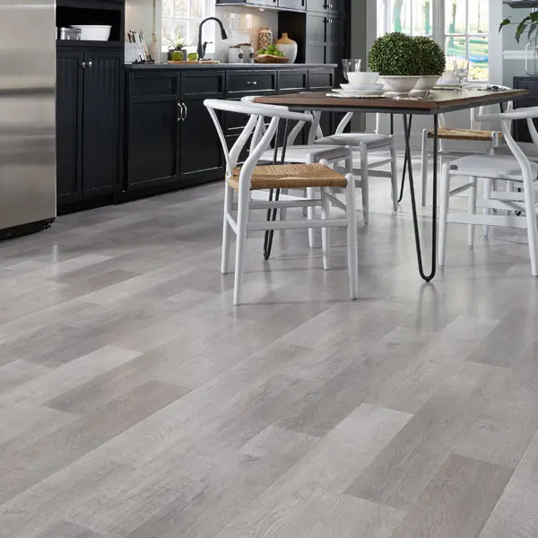 Kitchen scene - Refrigerator and counter, table and chairs, on tile flooring.