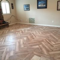 Great floor at a great price Customer's living room with parquet pattern wood-look lvp flooring.